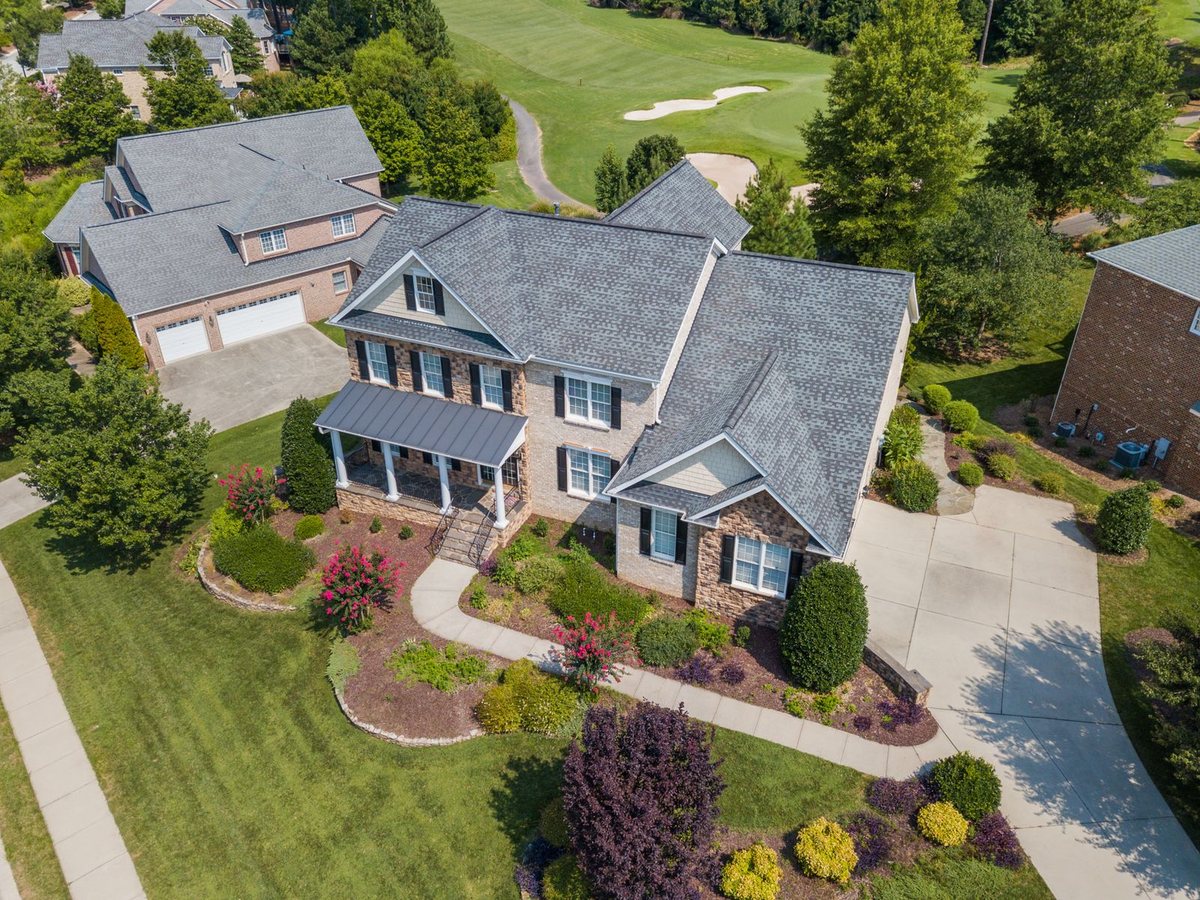 Residential property with a broad green lawn and tidy planted beds